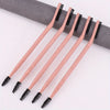 A set of five wooden dual-ended eyelash curlers and brow brushes arranged diagonally on a white surface.