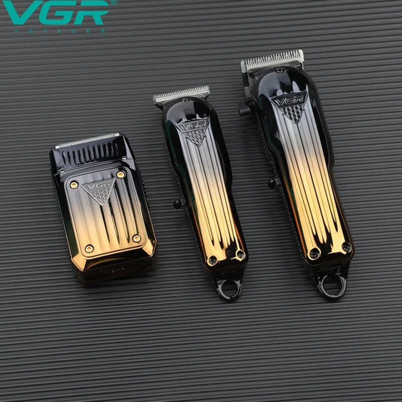 Set professioneller Haarschneider und Trimmer mit Gold- und Schwarz-Finish vor dunklem Hintergrund.
