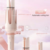 A set of pink ceramic hair curling irons with interchangeable rods displayed on a white surface.