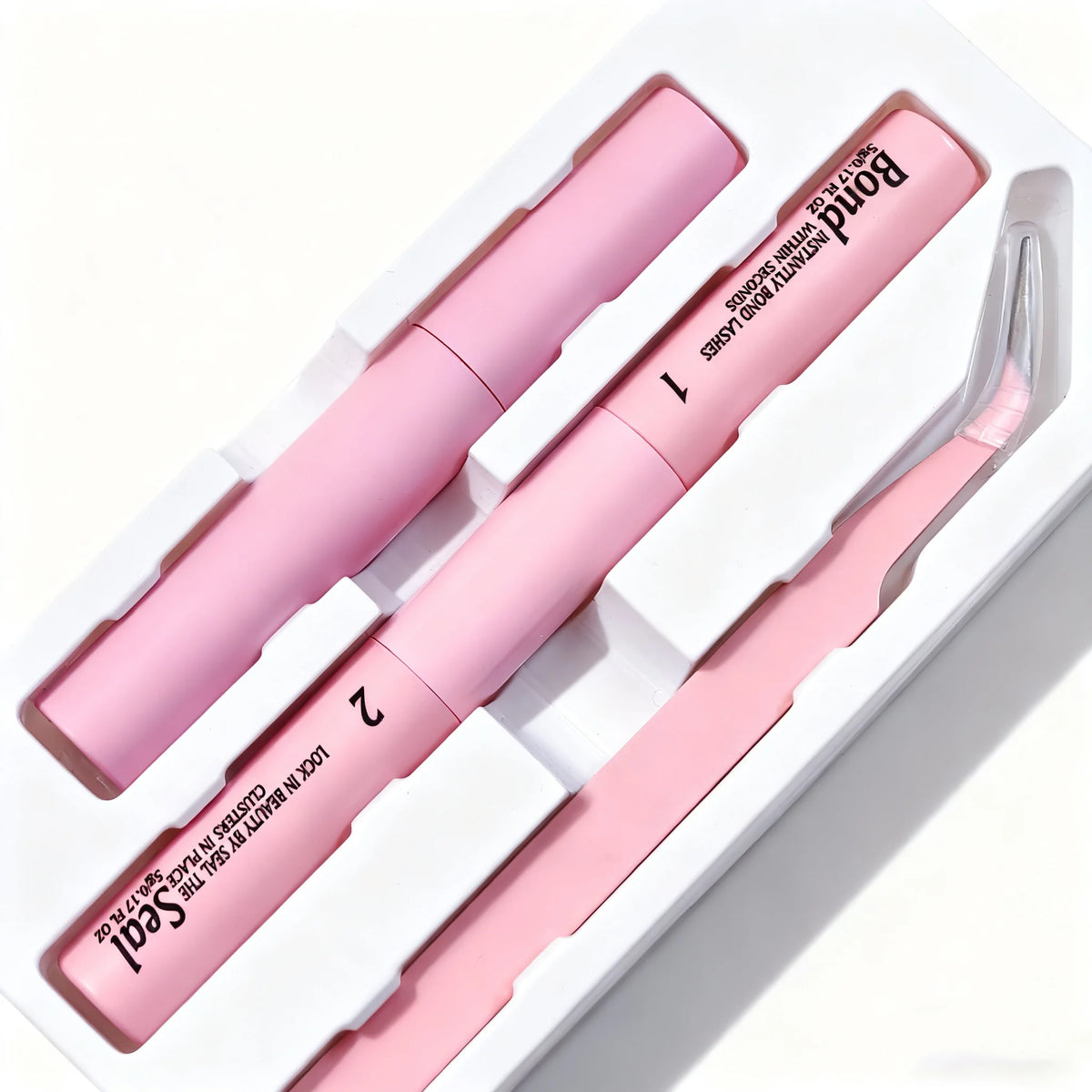 A white box containing a pink DIY lash extension kit with two lash rods and tweezers.