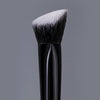 A black triangular precision concealer brush with a white synthetic hair tip.
