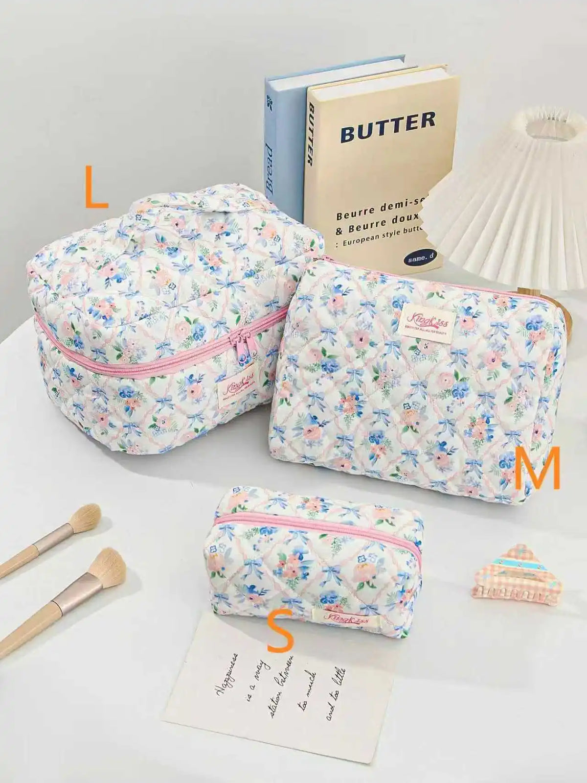 A collection of quilted cotton makeup bags in various floral patterns and colors, including a butter-themed bag.
