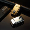 A close-up shot of a gold and silver reciprocating electric shaver resting on a dark surface.