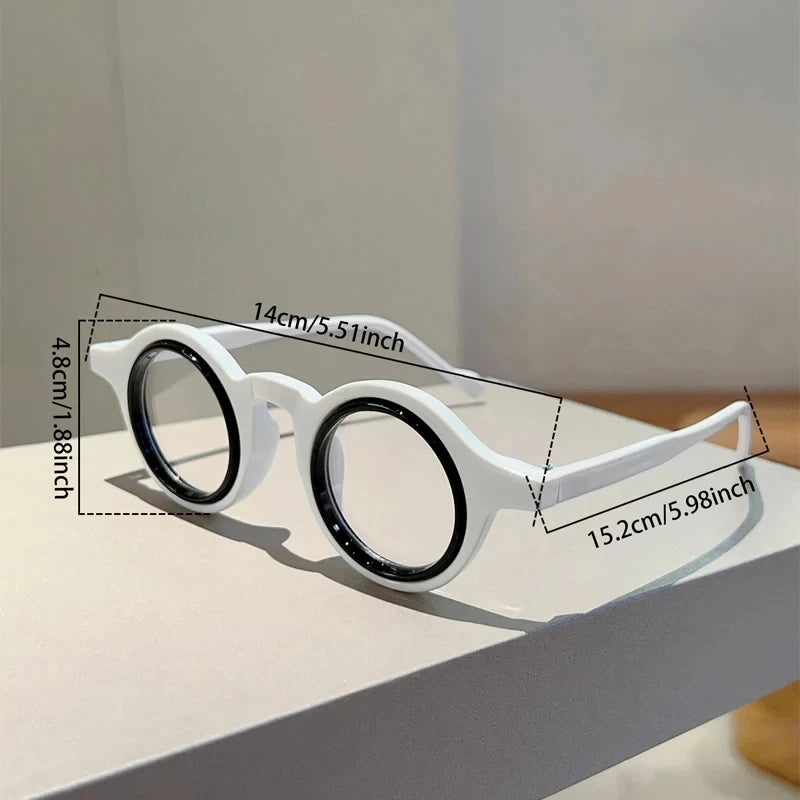 Une paire de lunettes de lecture transparentes et ajustables blanches, exposées sur une surface blanche avec des lignes de di