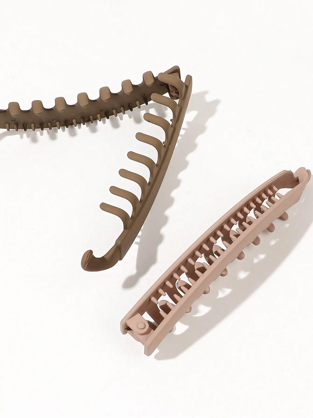 A set of five banana-shaped hair clips in a tan or beige color shown against a white background.