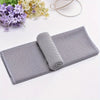 A folded gray microfiber sport towel with a rolled-up section is displayed on a white background.