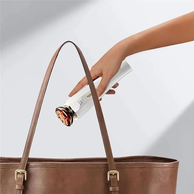 A hand is holding a white light therapy device inside a brown leather handbag.