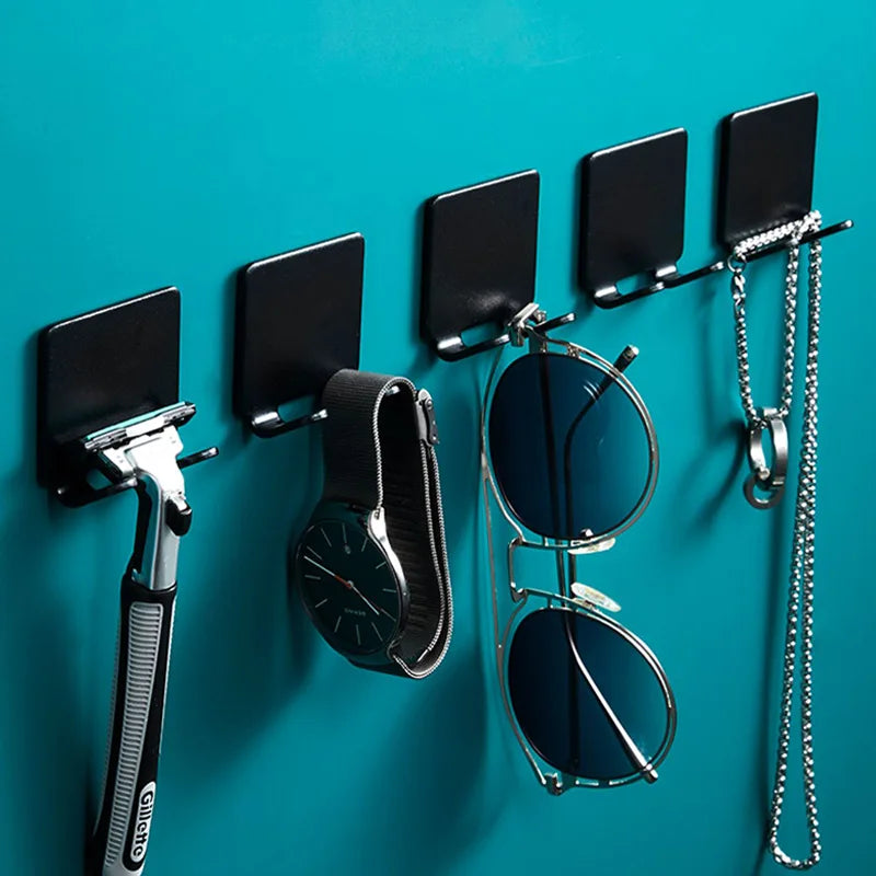 Support à rasoir multifonction noir avec rasoir et lunettes monté sur un mur bleu sarcelle.