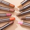 A collection of eyeshadow sticks in various shades and finishes arranged diagonally on a light background.