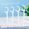 White reusable dental flossers and plastic toothpicks displayed on a white marble surface.