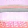 A close-up of a pink heated abdominal massage belt being used on the lower abdomen.