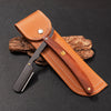A professional wood handle shaving razor with a tan leather sheath and dark wood handle resting on a black surface.
