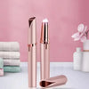 A rose gold automatic electric eyebrow trimmer with a protective cap and a separate trimming tool.