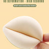 A hand is holding a white makeup sponge puff, demonstrating its flexible and non-deforming texture.