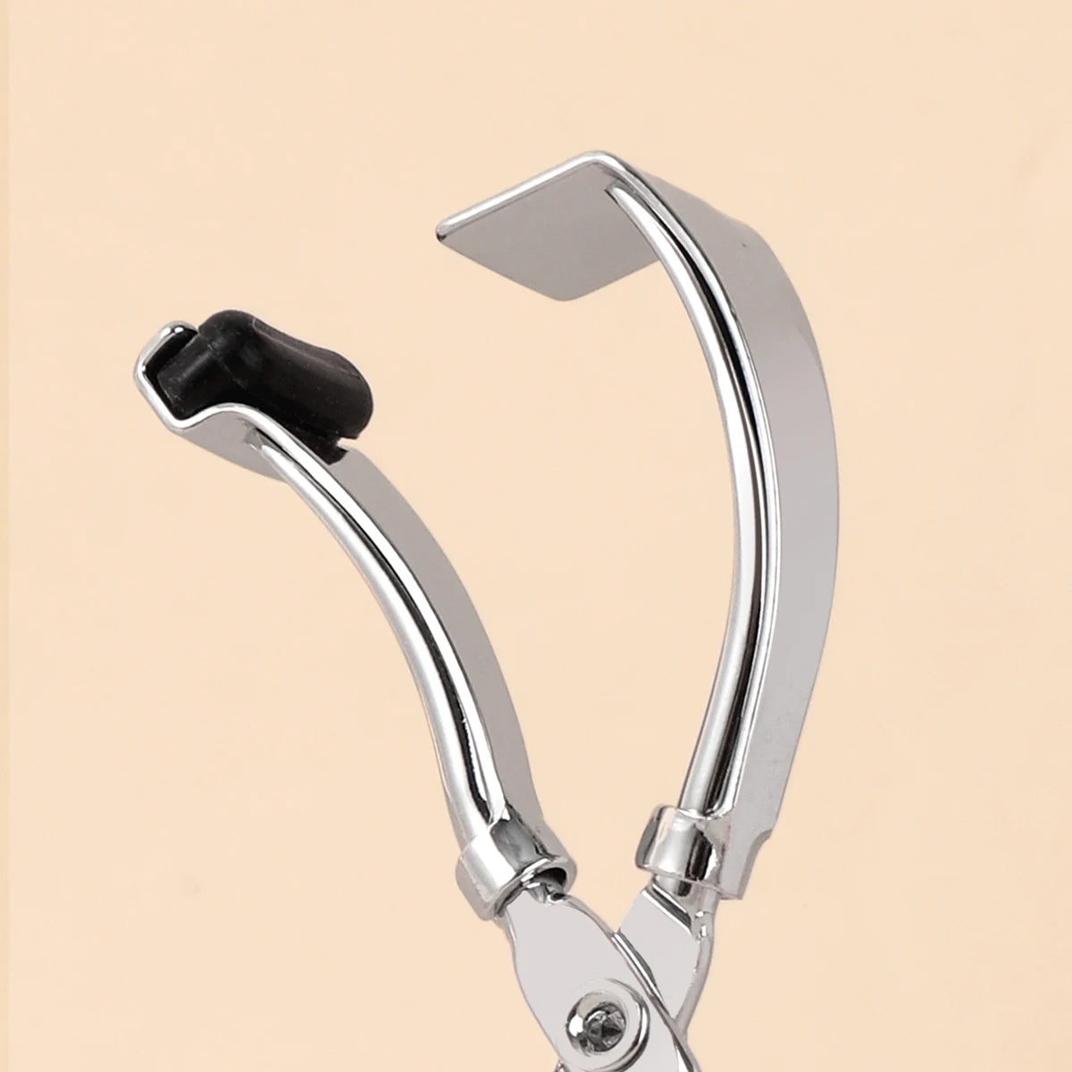 A close-up of a stainless steel wide-angle eyelash curler with a black pad.
