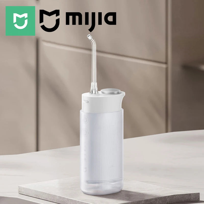 A white portable cordless oral irrigator with a long nozzle is displayed on a light surface.