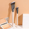 A set of two professional makeup brushes with silver ferrules and white handles displayed on a light surface.