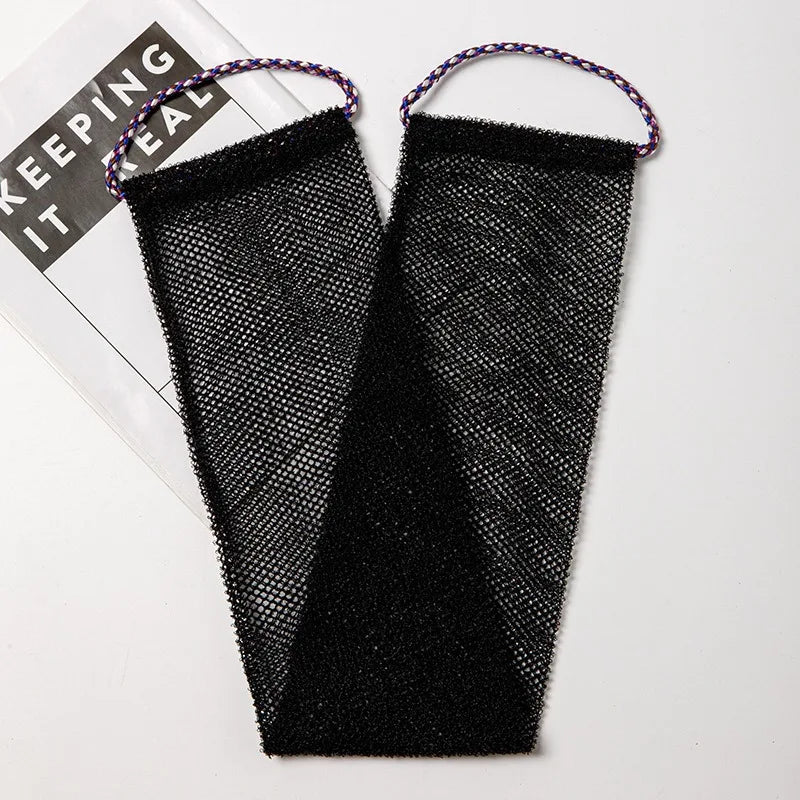 A pair of black exfoliating body scrub sponges with purple string handles are shown on a white background.