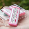 A pink safety razor with six blades is shown resting in a clear plastic case on a person's hand.