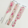 A set of dual hair combs in pink and green floral patterns with various sizes shown on a white background.