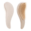 A beige detangling scalp massage hairbrush with fine, flexible bristles shown from the side.