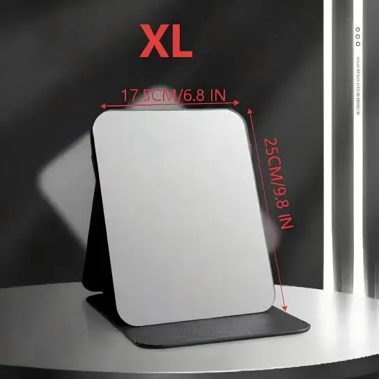 A white foldable portable makeup mirror is displayed on a dark surface with size markings.