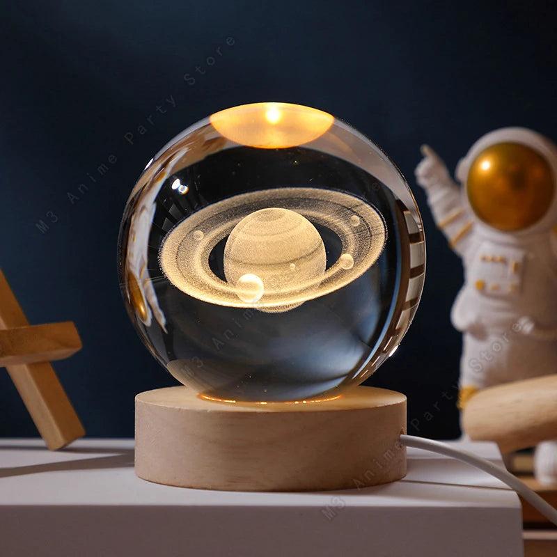 A glass crystal ball night light featuring a glowing solar system model on a wooden base.