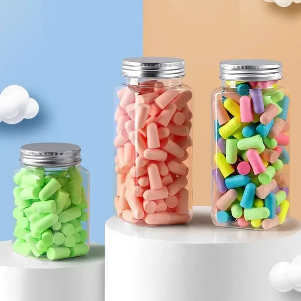 Glass jars filled with colorful memory foam earplugs in pink, green, and blue.