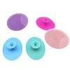 Un set de cinco cepillos de limpieza y masaje facial de silicona en tonos morado, rosa y azul.