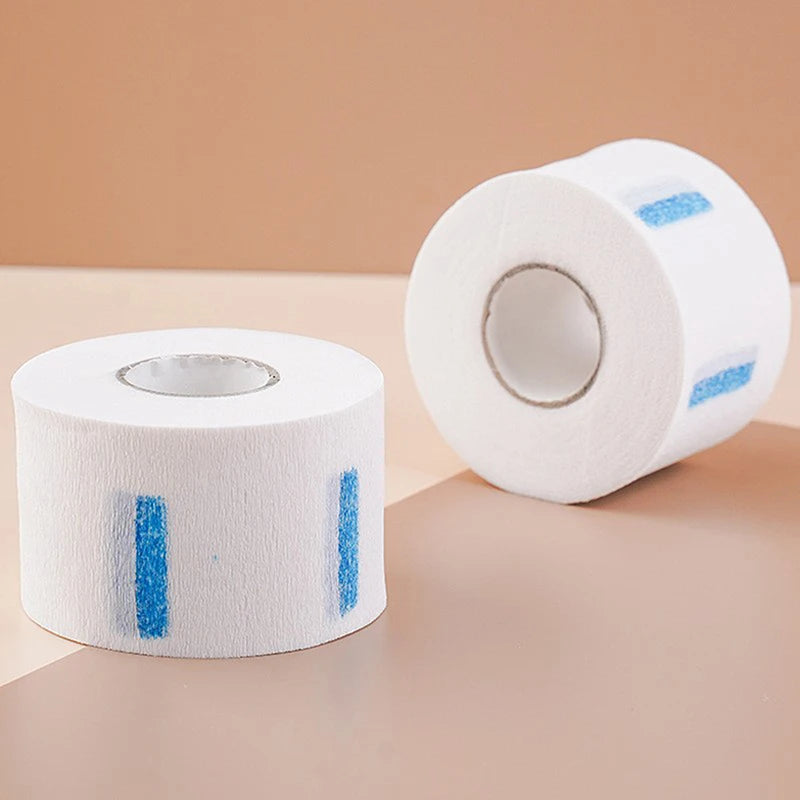 Roll of white professional hair dressing collar with blue stripes on a light brown surface