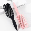 Peigne de coiffure professionnel en boucles noir et rose sur fond blanc.