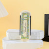 A white folding pocket hair comb with a mirror and scalp massage cushion displayed on stacked white blocks.