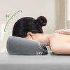 A person is lying down using a gray ergonomic memory foam pillow set at a 135-degree angle for relaxation.