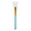 A silicone facial mask applicator brush with a white head and a gold handle.