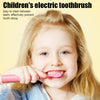 A smiling young girl holding a pink electric toothbrush and demonstrating its use.