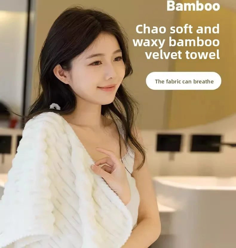 Une femme tient une serviette en velours de bambou blanc, montrant sa texture douce et cireuse.