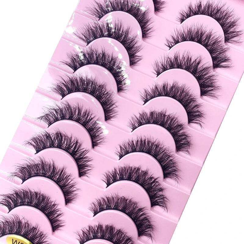 Un plateau en plastique rose contenant diverses variétés de faux cils de renard noirs.