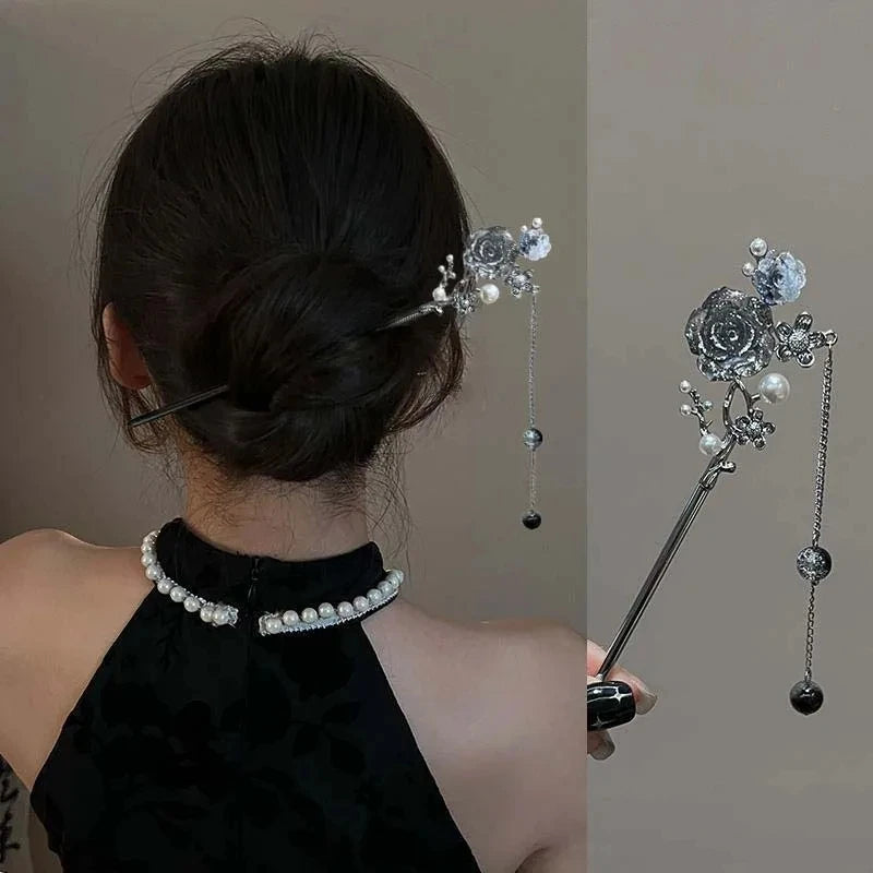Una mujer muestra horquillas para el cabello con borlas de mariposa vintage, adornadas con plata y perlas.