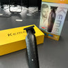 A black cordless electric hair clipper is displayed in front of its packaging box.