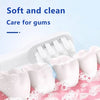 White replacement toothbrush heads resting on a pink surface with foam.