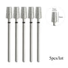 A set of five silver diamond nail drill bits with varying sizes shown next to a scale.