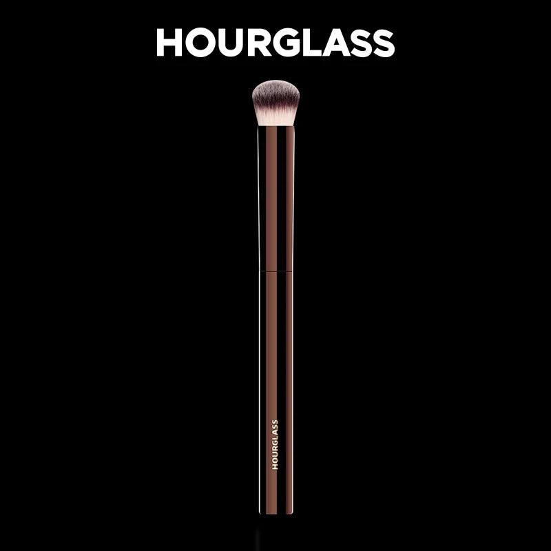 Un long pinceau de maquillage élancé avec une pointe effilée, présenté sur fond noir.