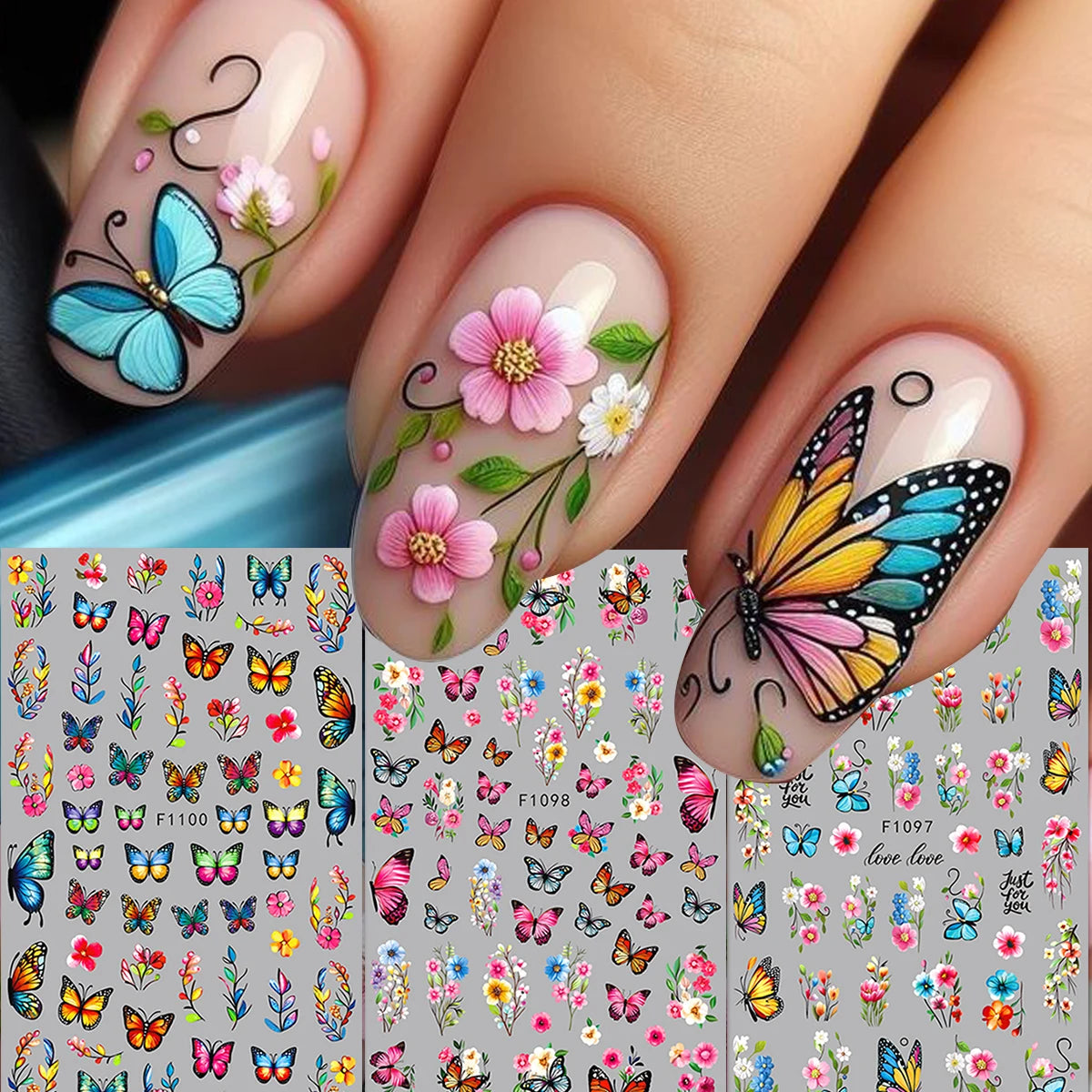 A close-up of a hand displaying long, natural-colored nails decorated with delicate pink and blue flower butterfly nail stick