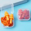 Un récipient en plastique transparent contient des bouchons d'oreille en silicone orange et un paquet de bouchons rouges.
