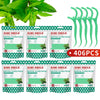 A set of green mint flavor dental floss picks packaged in a clear plastic case.