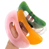 Trois planches de massage Guasha en pierre naturelle rose, orange et vert tenues par une main.