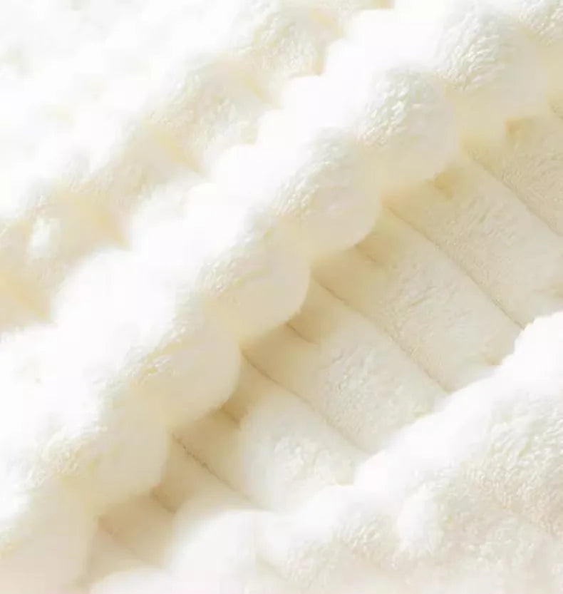 Gros plan d'une serviette de bain en velours de bambou blanc de luxe avec texture et plis visibles.