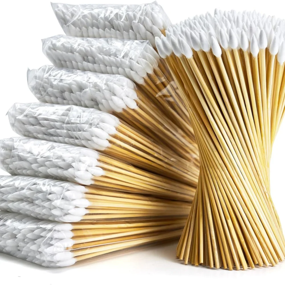 A stack of precision wooden cotton swabs with white cotton tips and natural wood sticks.