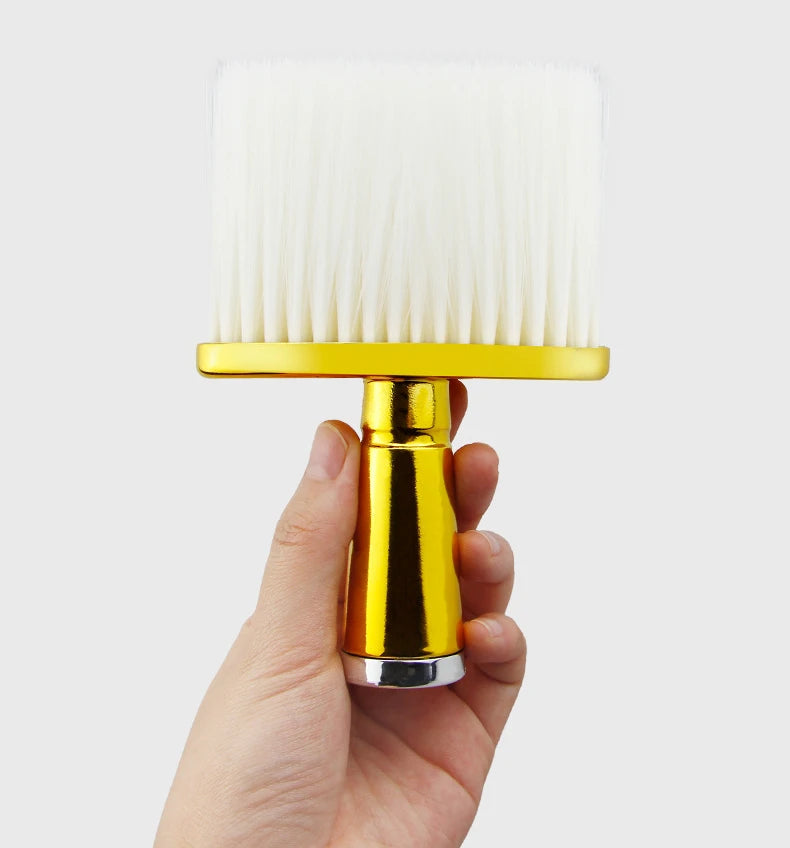 Eine Hand hält eine goldfarbene professionelle Haarbürste mit weißen Borsten.