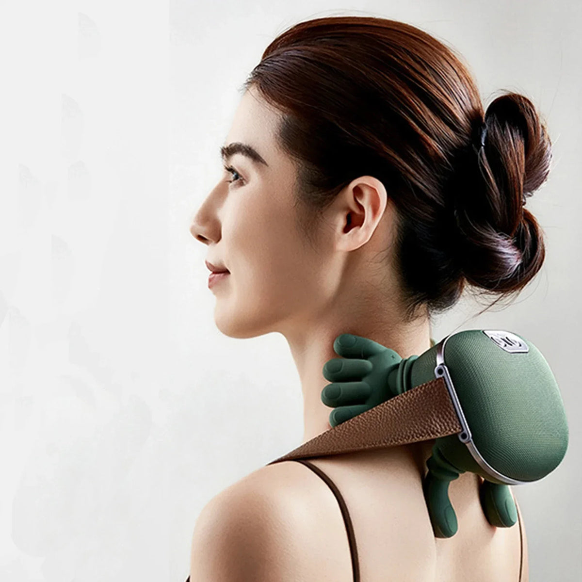 A woman is shown using a green deep tissue shiatsu massager on her neck and shoulder area.